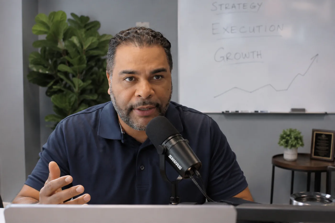 Farhat Muruwat, founder of Ranking Out, speaking to camera at his desk with a microphone.
